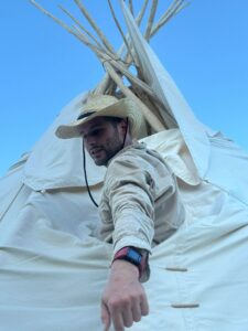 Tipiaufbau_ Mann schaut aus dem Tipi