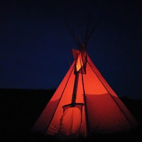 Tipi von aussen im Dunkeln, leuchtend rot